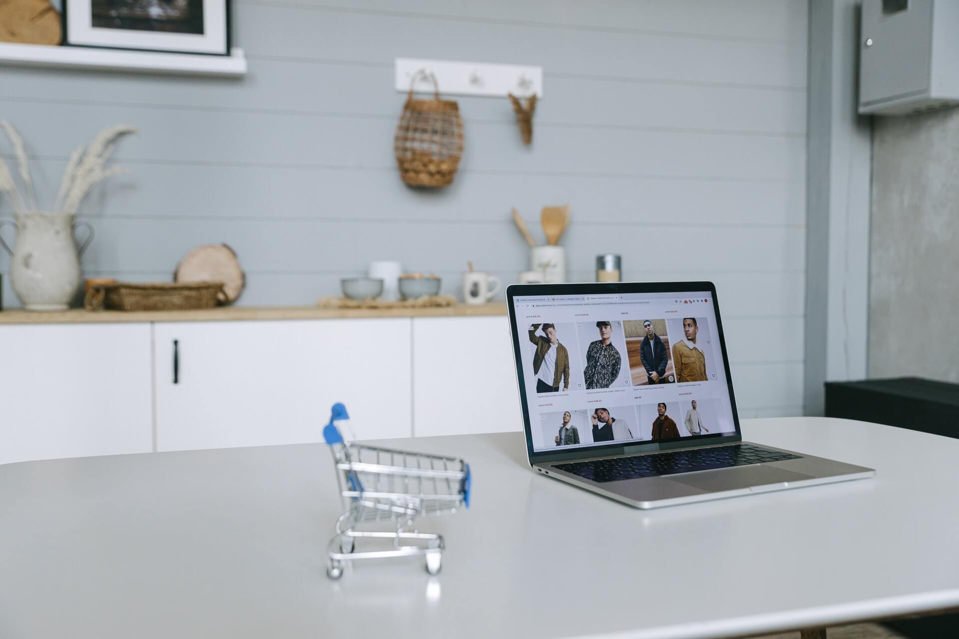 Imagem mostra um carrinho de compras e um notebook, simbolizando como vender pela internet